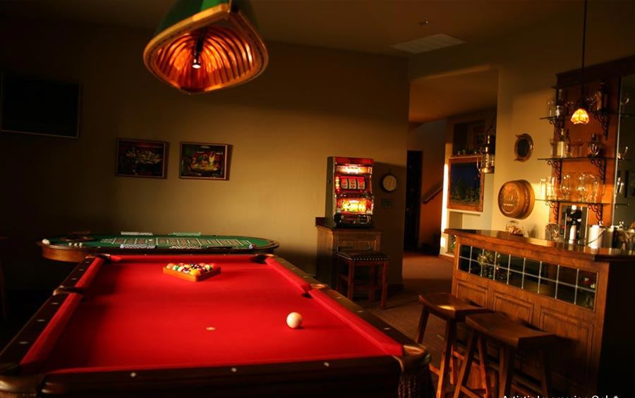A warmly lit indoor games room with a pool table