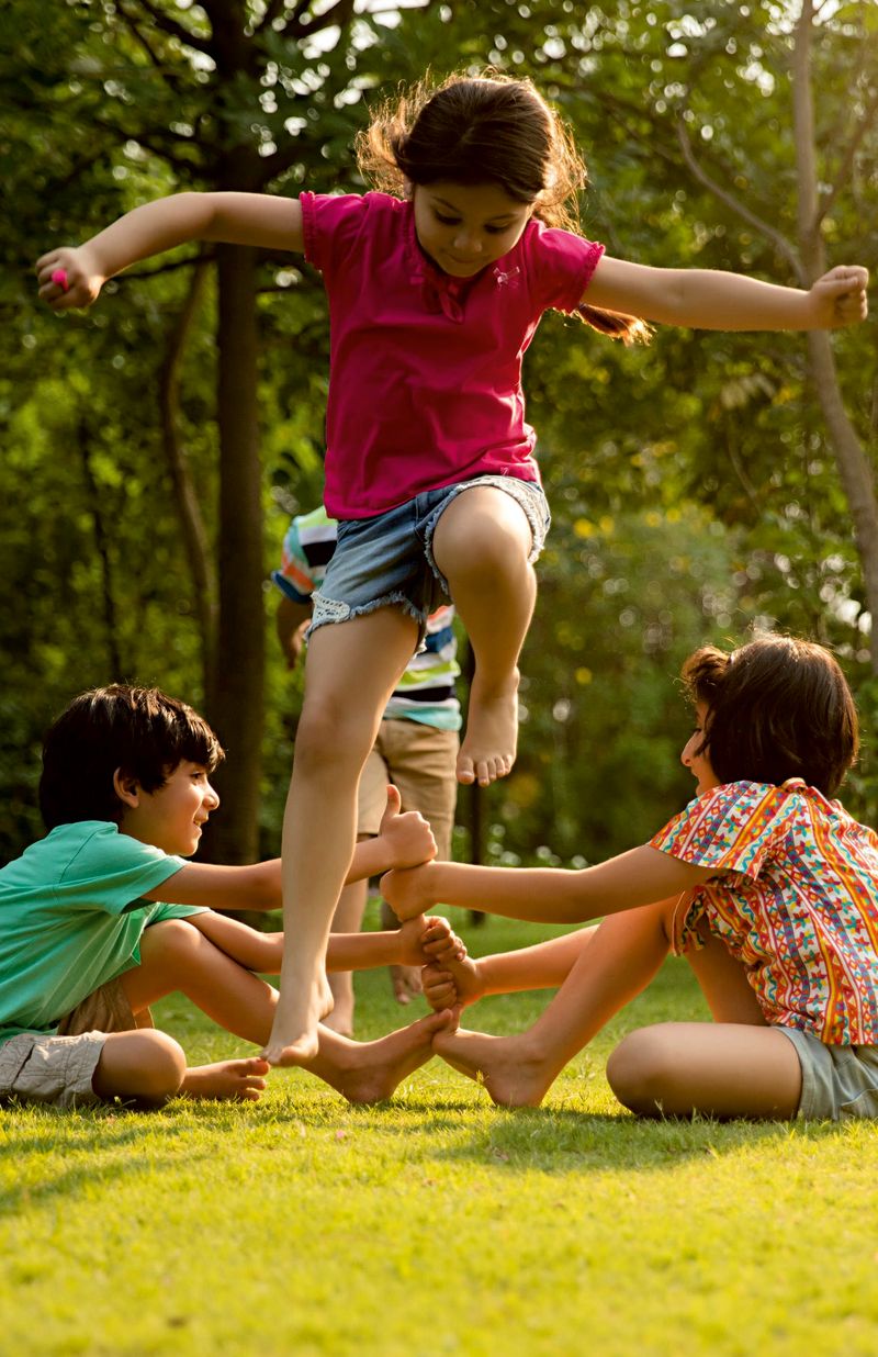 Children playing a jumping game on the grass